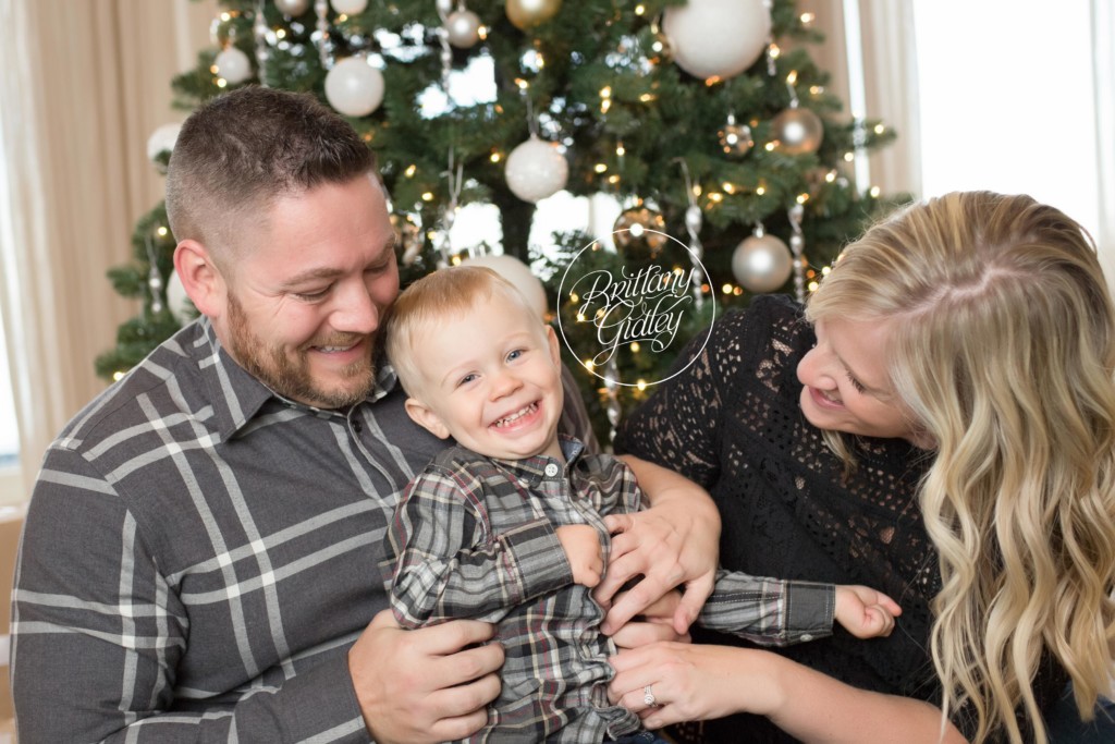 Family Poses In Front of Christmas Tree | Brittany Gidley Photography LLC
