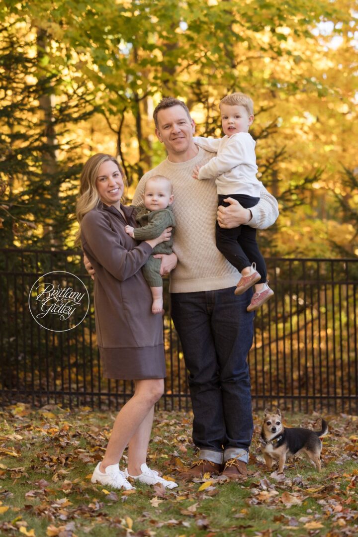 Miller family with their dog Poppy in front of golden fall trees at their Aurora Ohio home