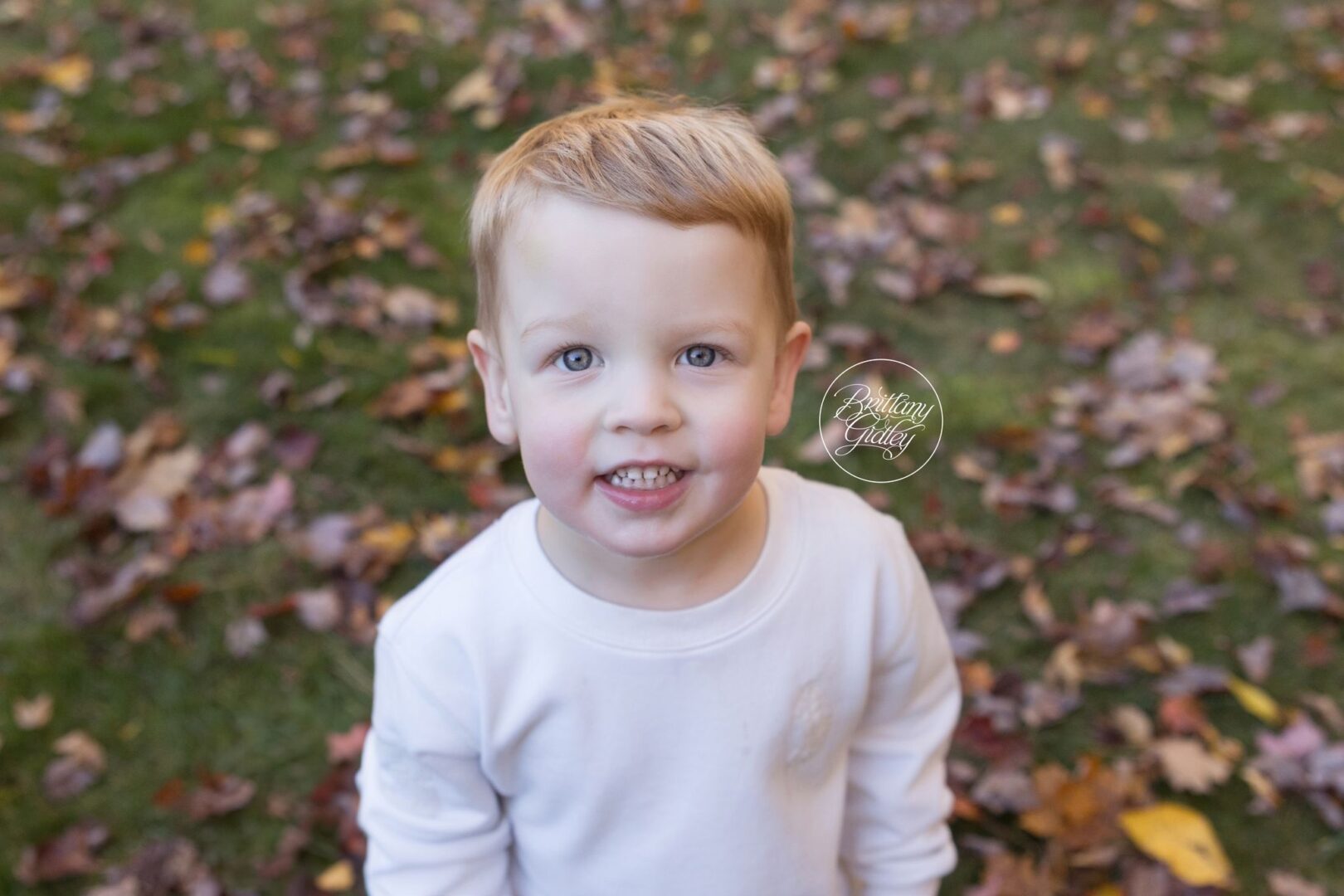 Close-up of Miles smiling in the fall leaves