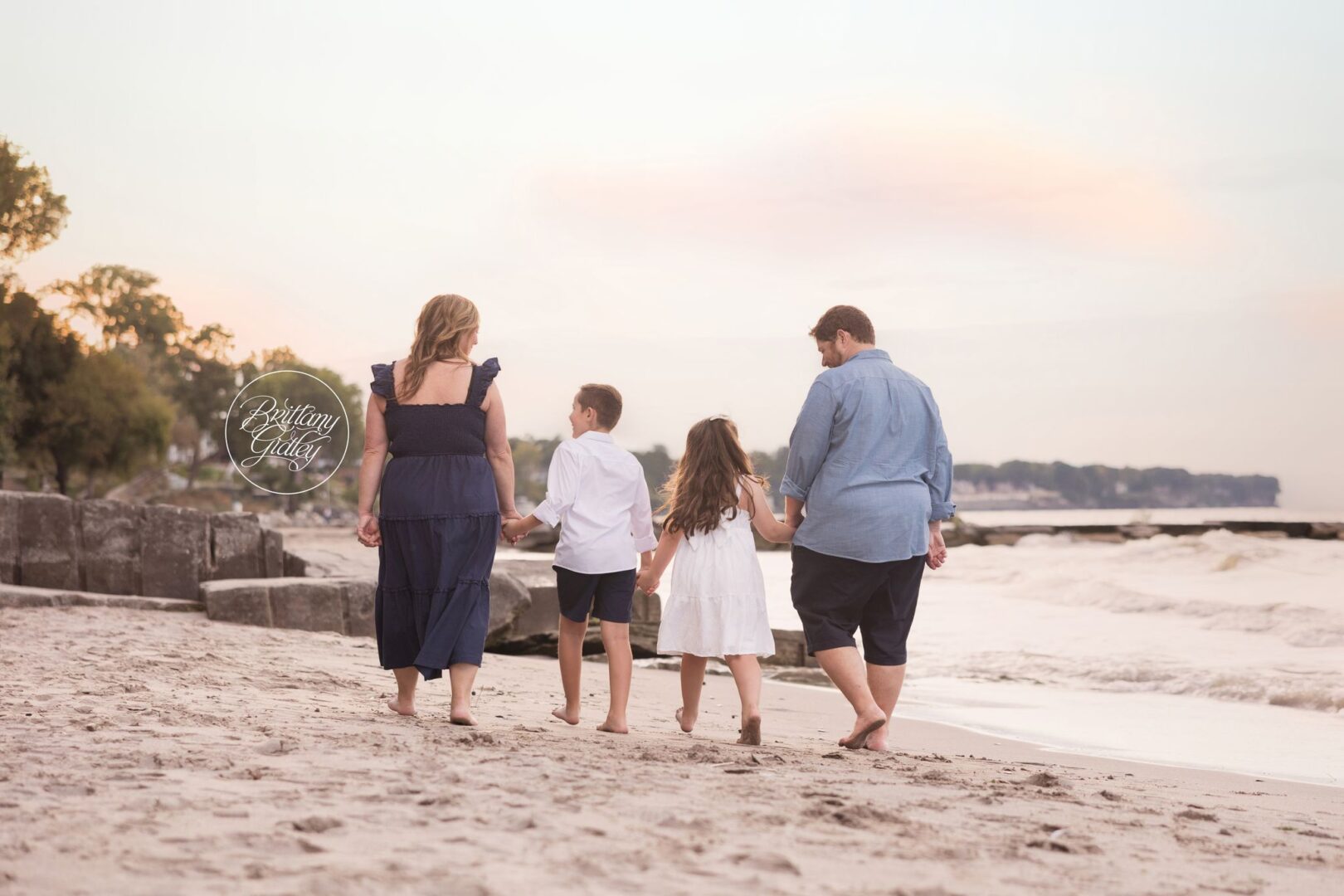 Family walking hand in hand along the Lake Erie shoreline at Huntington Beach