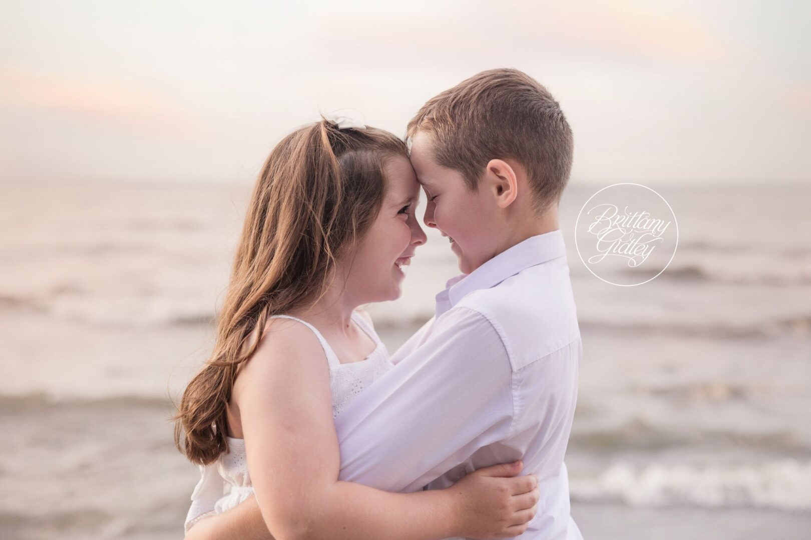 Siblings touching foreheads at sunset on Huntington Beach, Cleveland area family photography