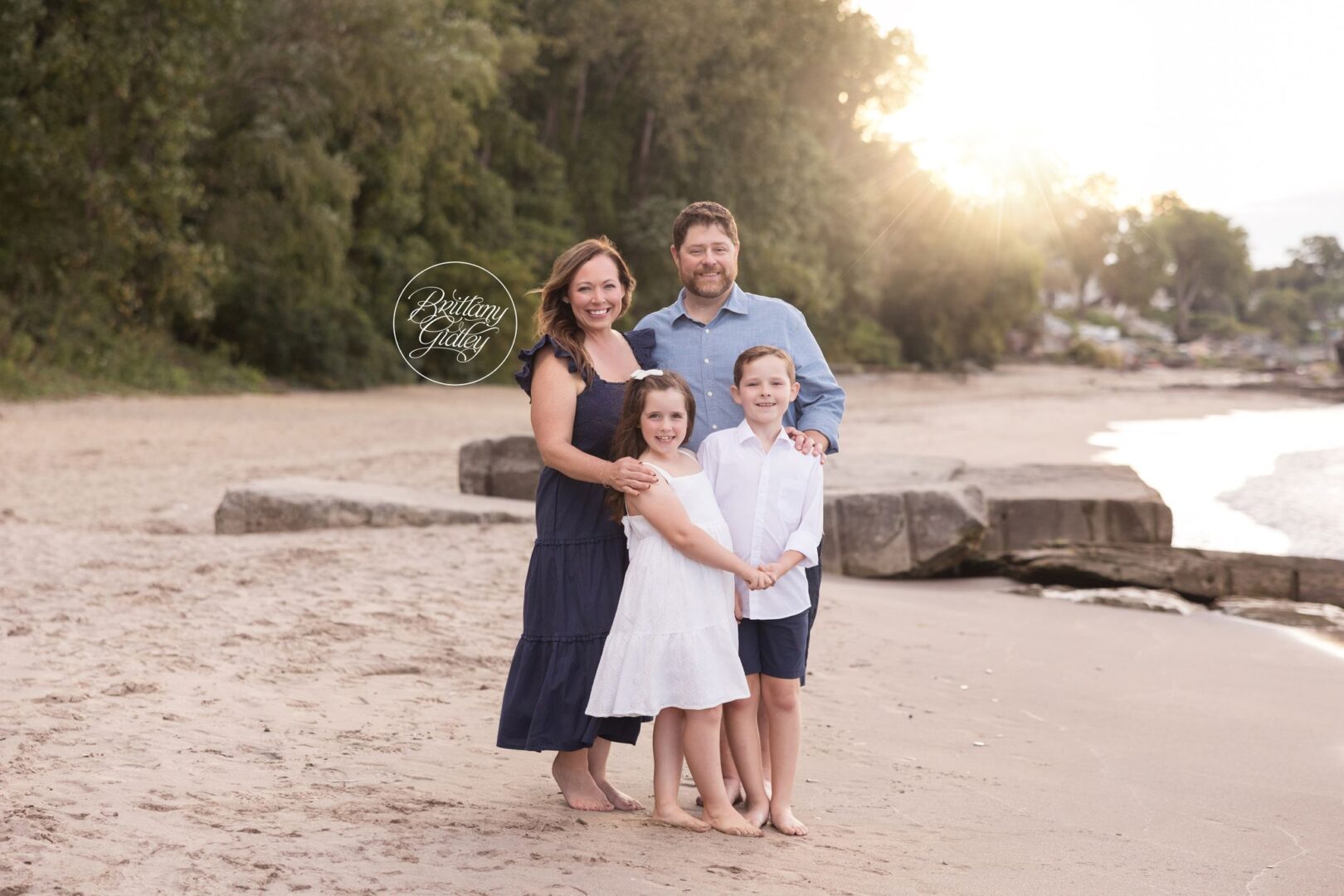 Lavin family hugging on Huntington Beach at sunset in Bay Village, Ohio