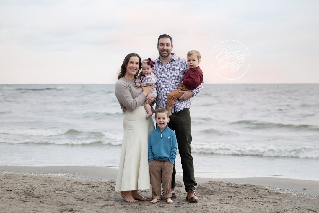 Yost family of five standing together on Huntington Beach with Lake Erie behind them in Bay Village, Ohio