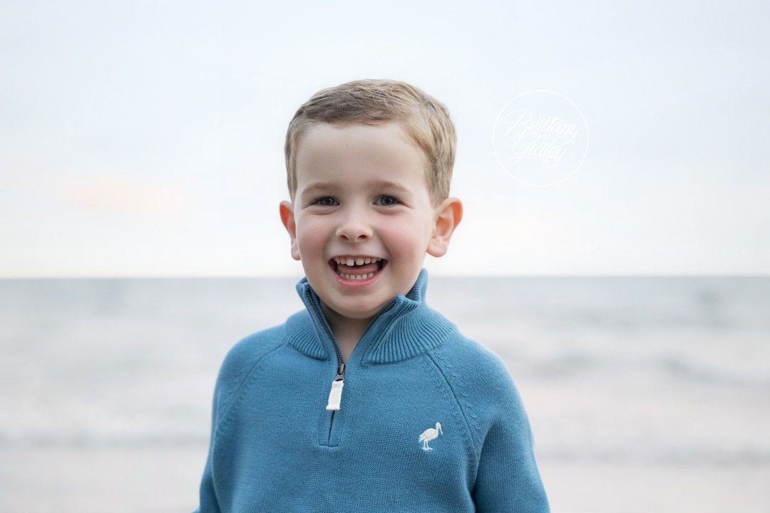 Smiling boy in a blue sweater on Huntington Beach, Bay Village family photographer