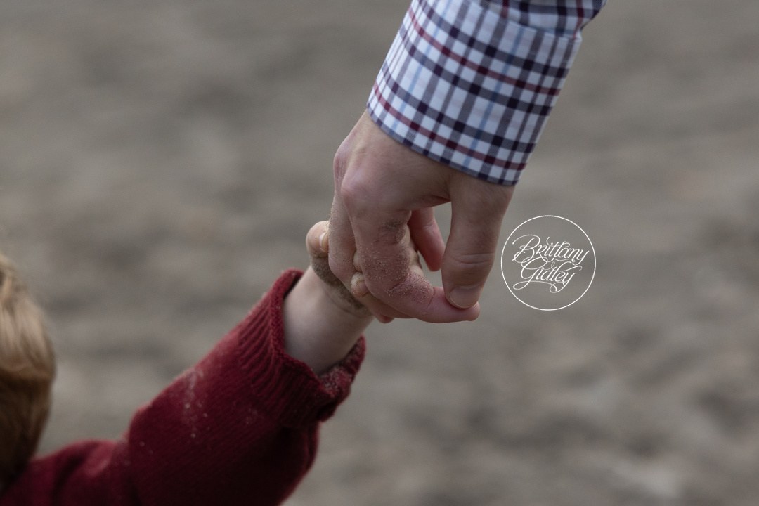 Toddler holding his dad's finger, a sweet detail from a Bay Village family session