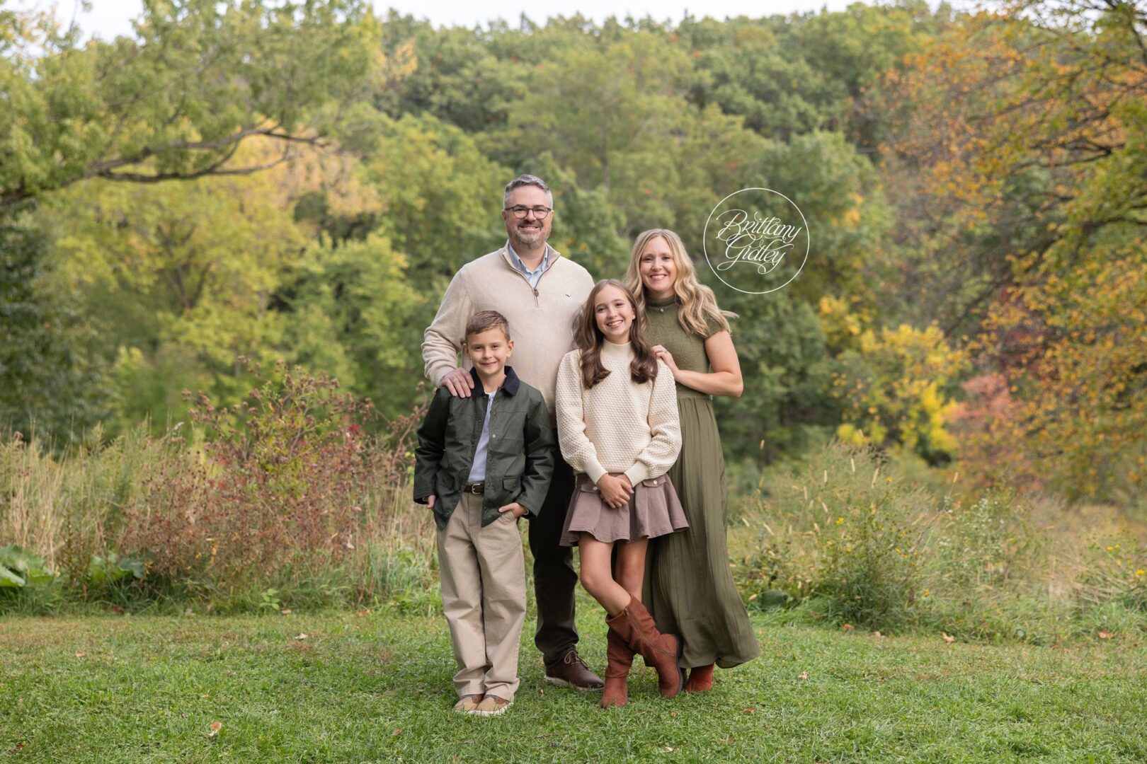 Hopkins family of four standing together in a fall meadow at Bay Field in Bay Village, Ohio
