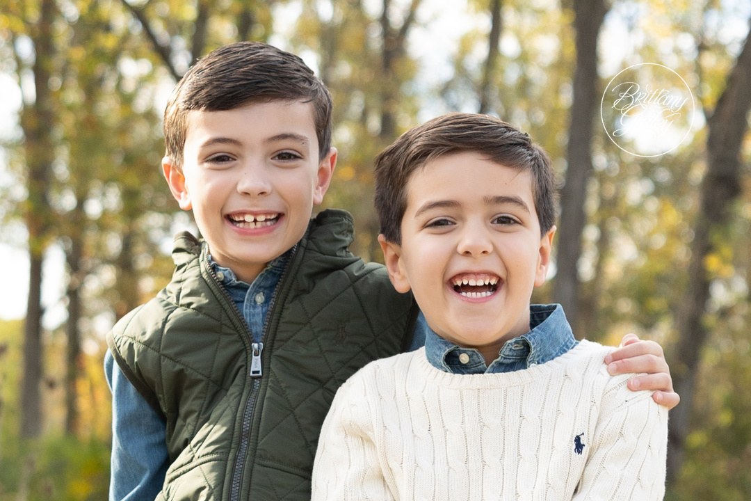 Two brothers laughing cheek to cheek in the fall woods, Brecksville family photographer