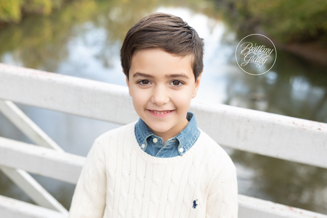 Smiling younger boy in a cream cable knit sweater at Brecksville Reservation