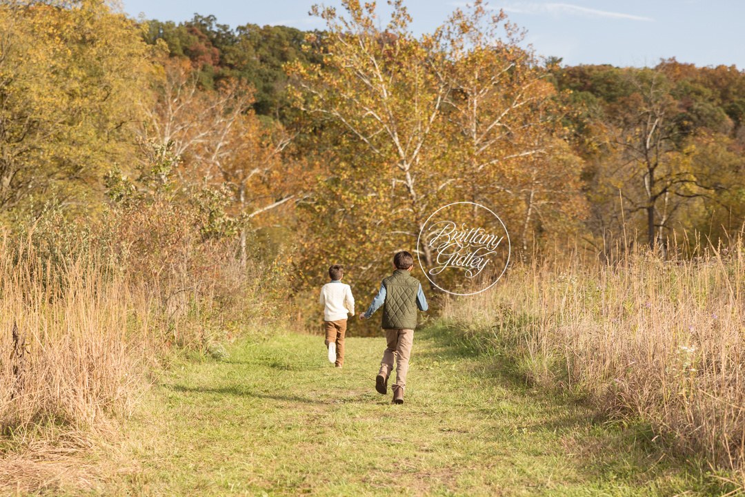 Two brothers running down a grassy trail through fall meadows in Brecksville, Ohio