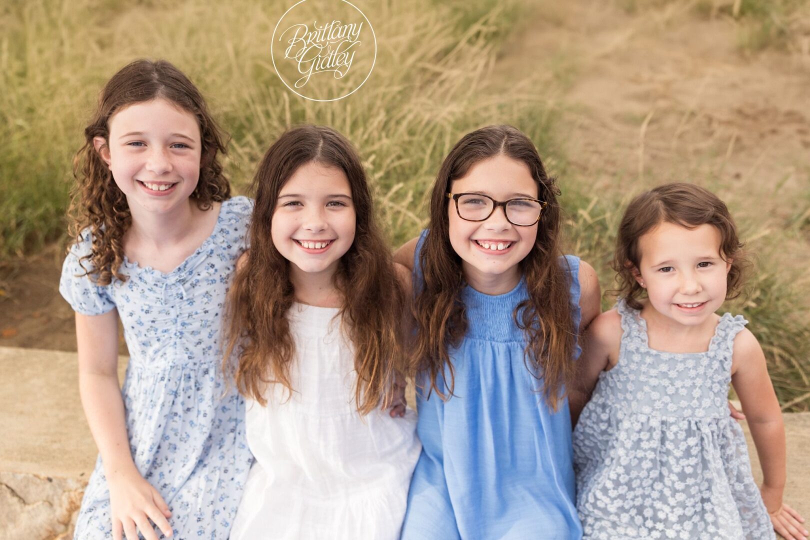 Four sisters smiling in the dune grass at Edgewater Beach