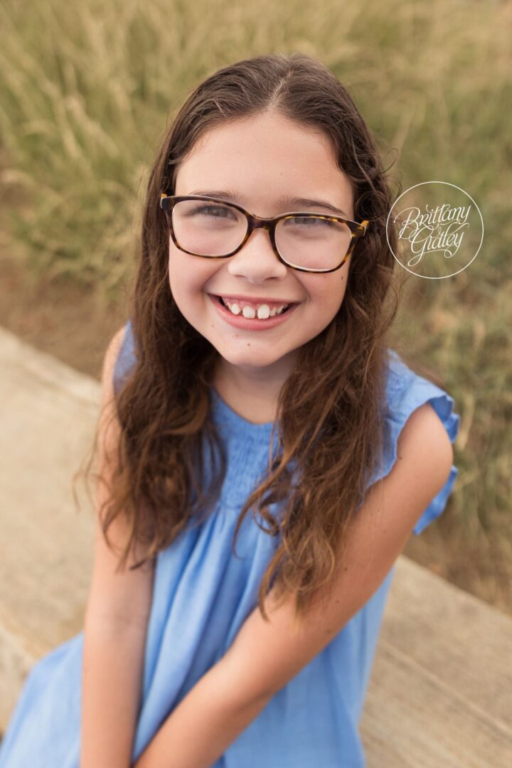 Smiling girl in glasses and a blue dress on the beach in Cleveland