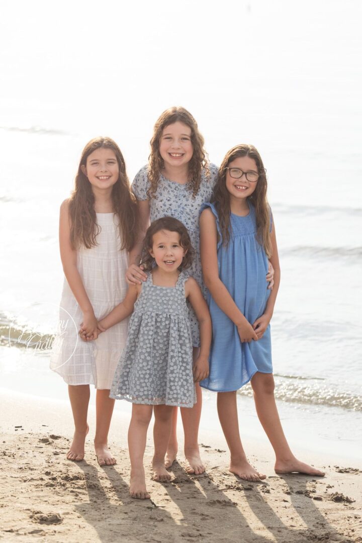 Four sisters standing together by the waves of Lake Erie