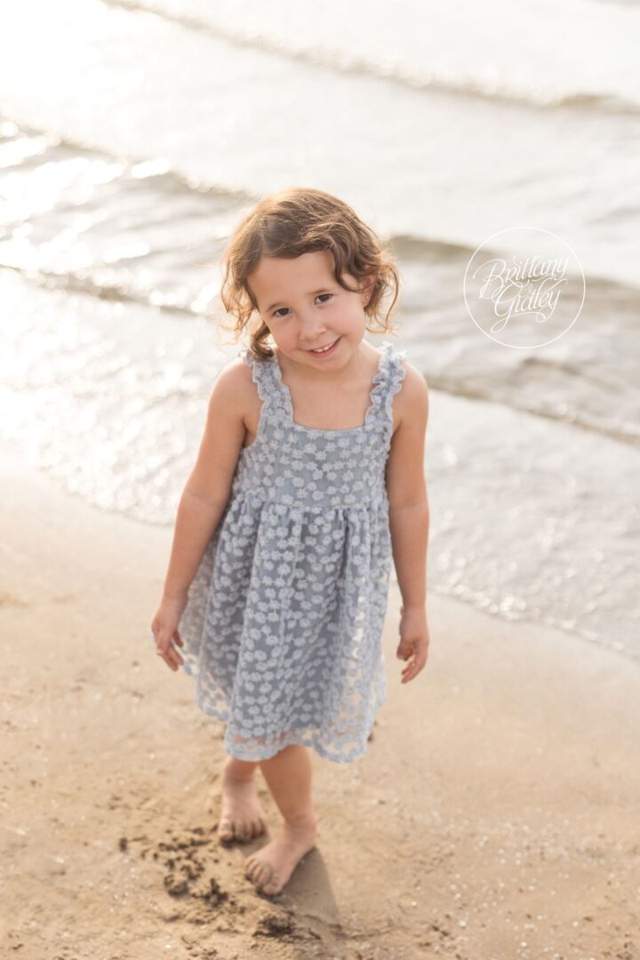 Little girl walking barefoot in the sand at Edgewater Beach
