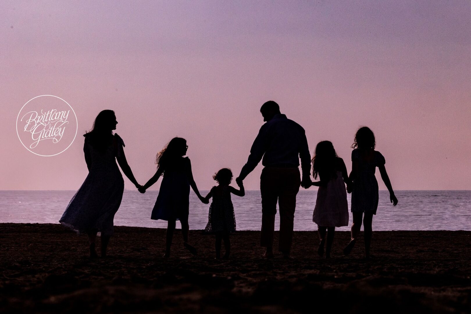 Lindow family silhouette holding hands at sunset on Lake Erie