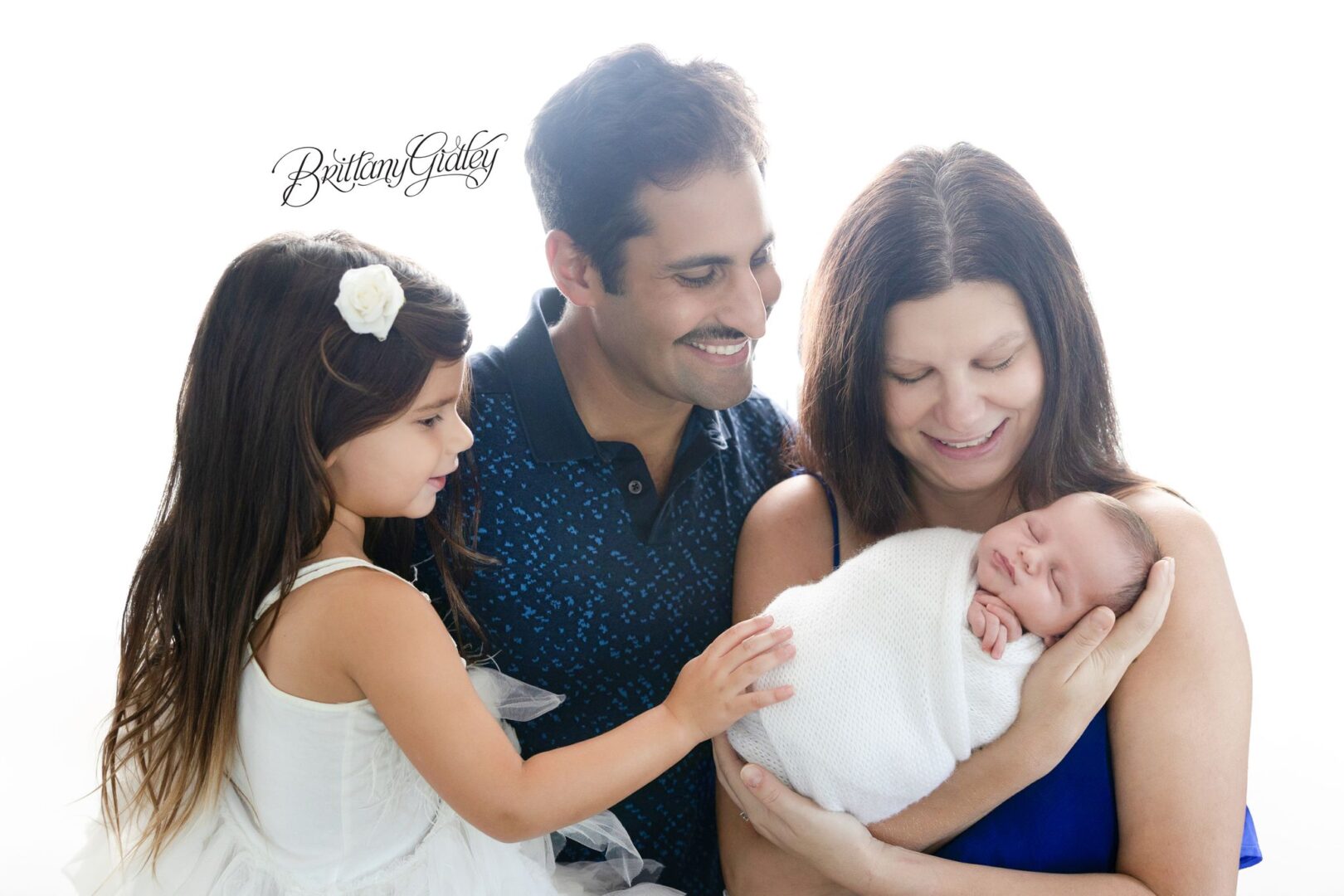 Mom and Dad holding newborn Theodore while big sister touches his blanket in Erie, Pennsylvania