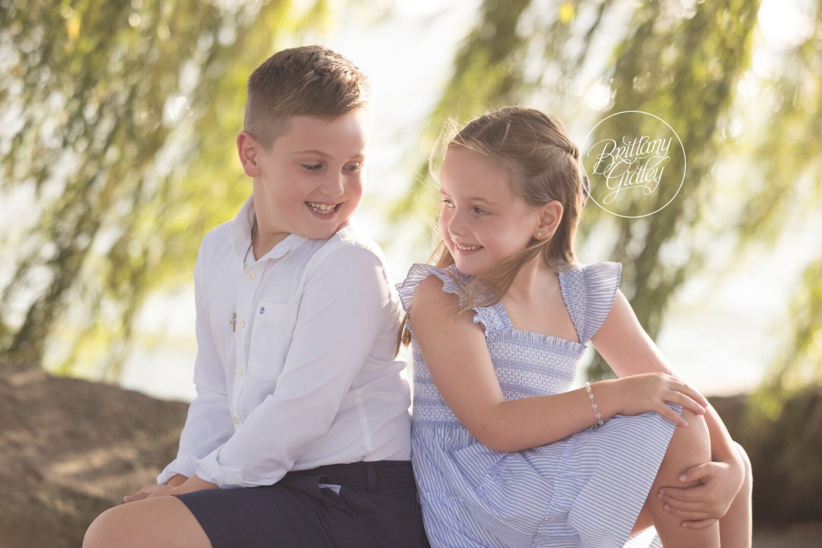 Brother and sister smiling at each other on the rocks at Edgewater Beach