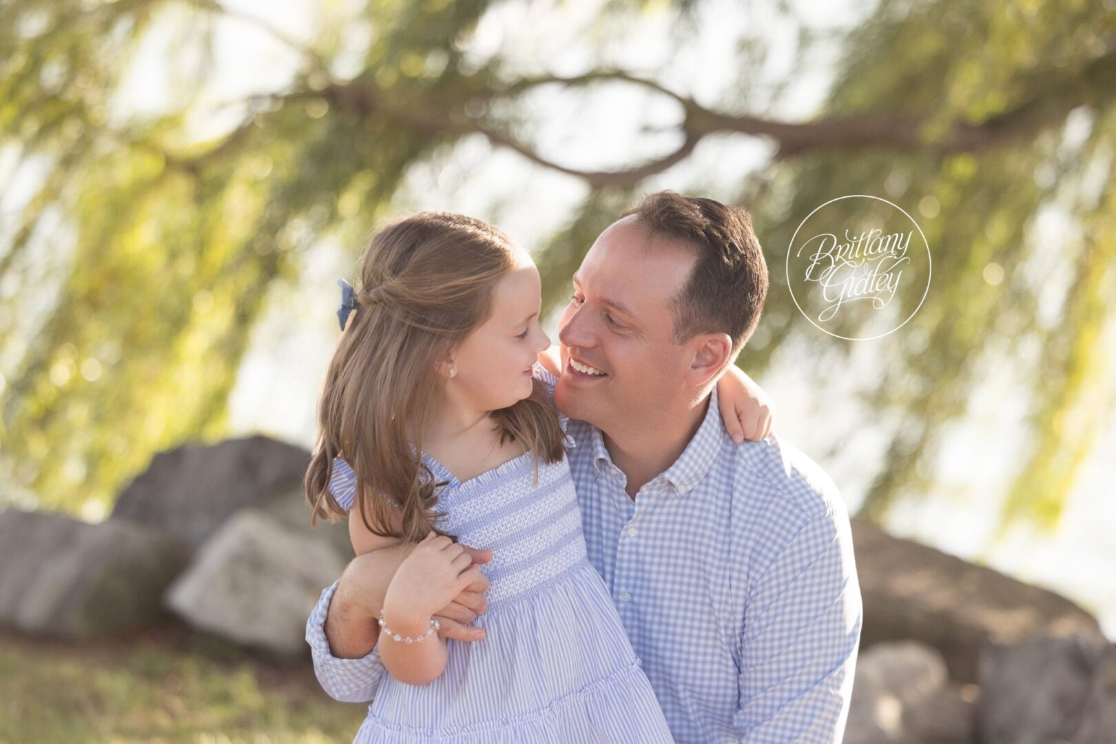 Dad and daughter cheek to cheek under the willow tree at Edgewater Park