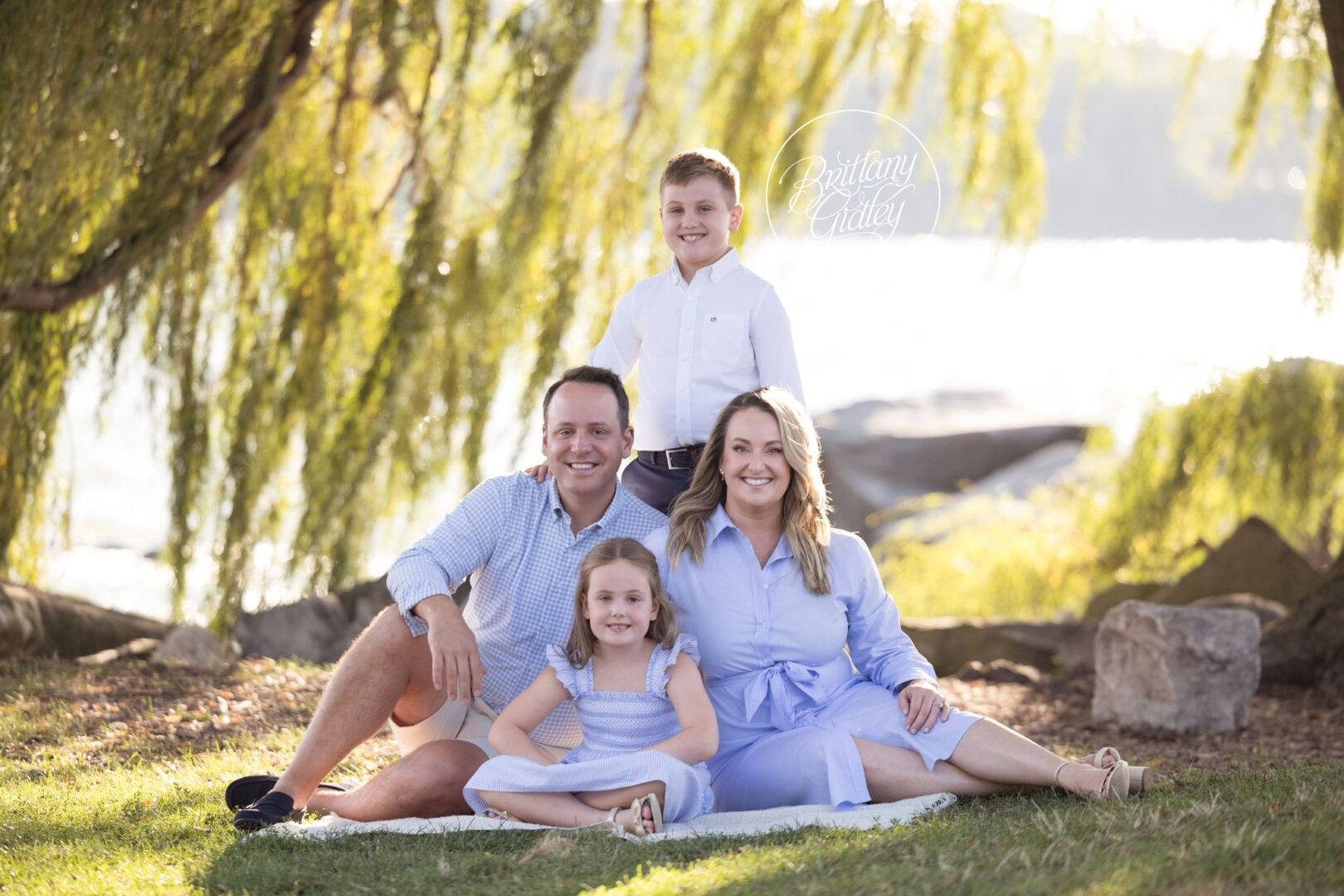 Family sitting together on a blanket in the grass at Edgewater Park