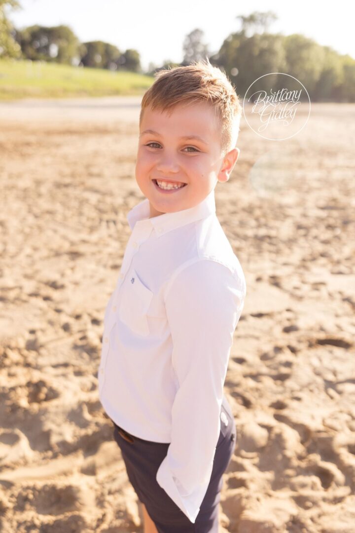 Smiling boy in a white button-down on the beach at Edgewater Park in Cleveland