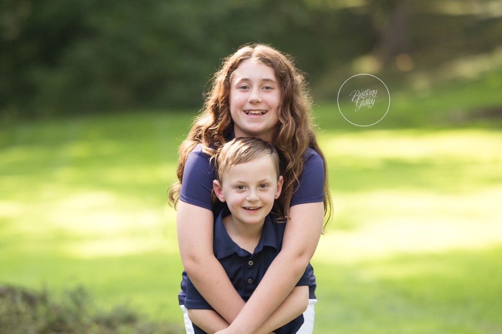 Big sister hugging her little brother on the lawn at home, Gates Mills in home family photographer