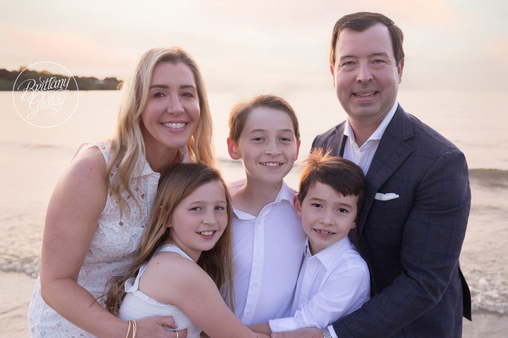 Mitchell family hugging on the beach at sunset in Cleveland