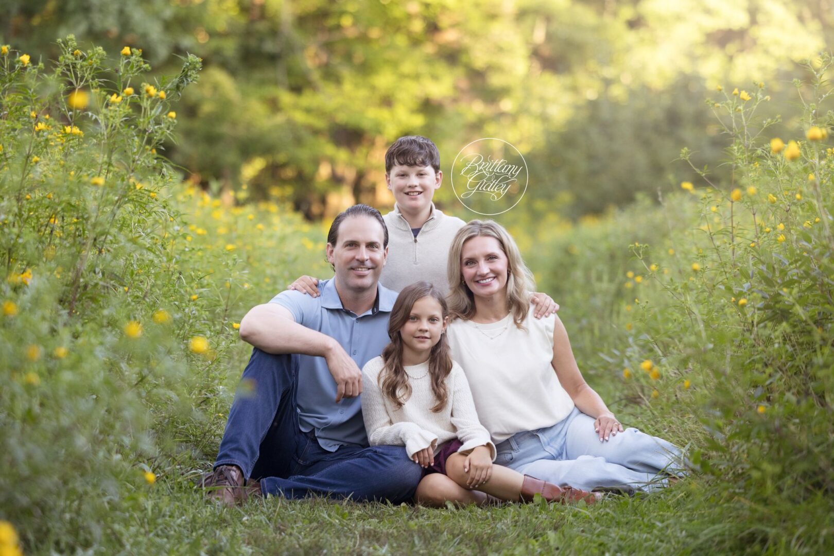 Clark family of four sitting together in a wildflower meadow at Bay Field in Bay Village, Ohio
