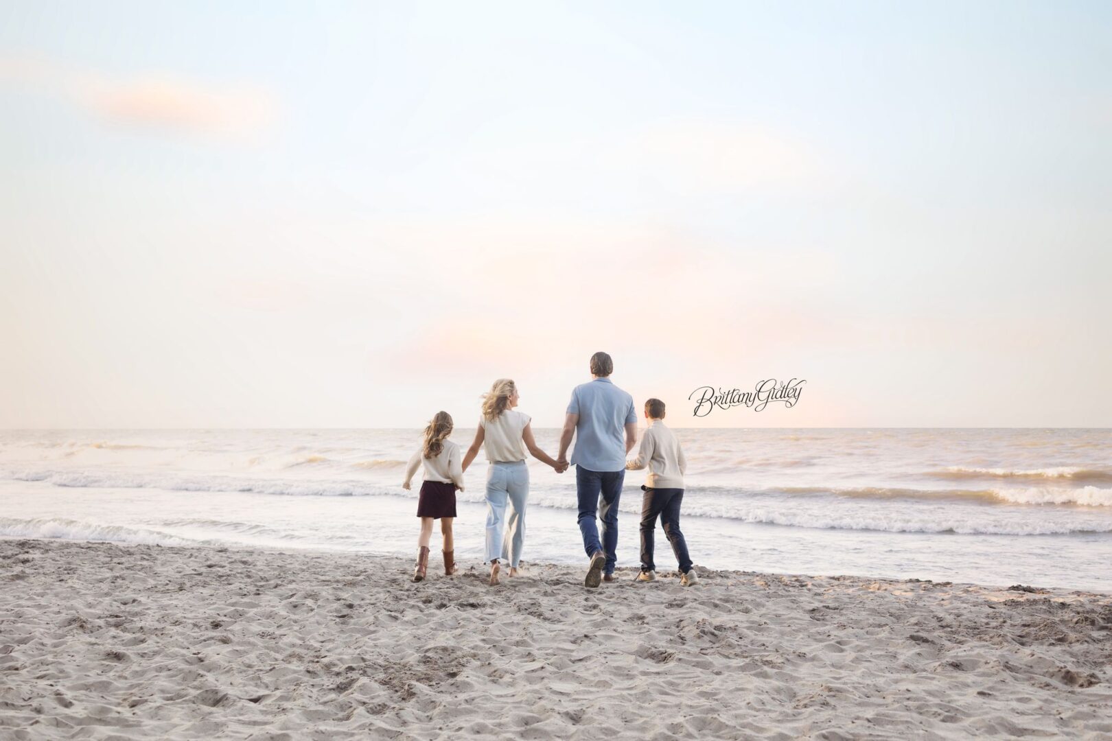 Family walking hand in hand toward Lake Erie at sunset on Huntington Beach